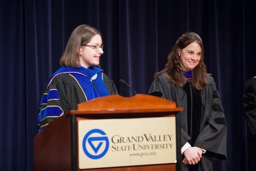 Faculty member smiles while being addressed by Christine Rener
